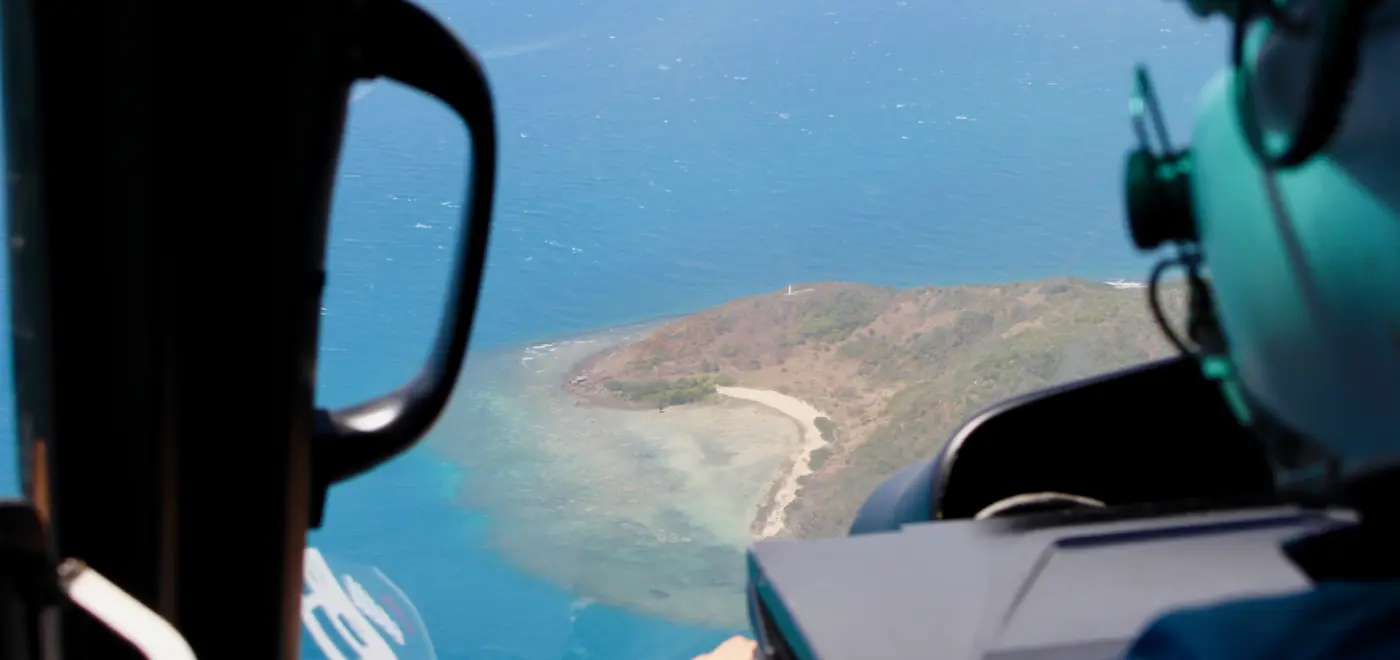 Pemandangan udara pulau pesisir kecil di Australia yang dilihat dari dalam kokpit helikopter