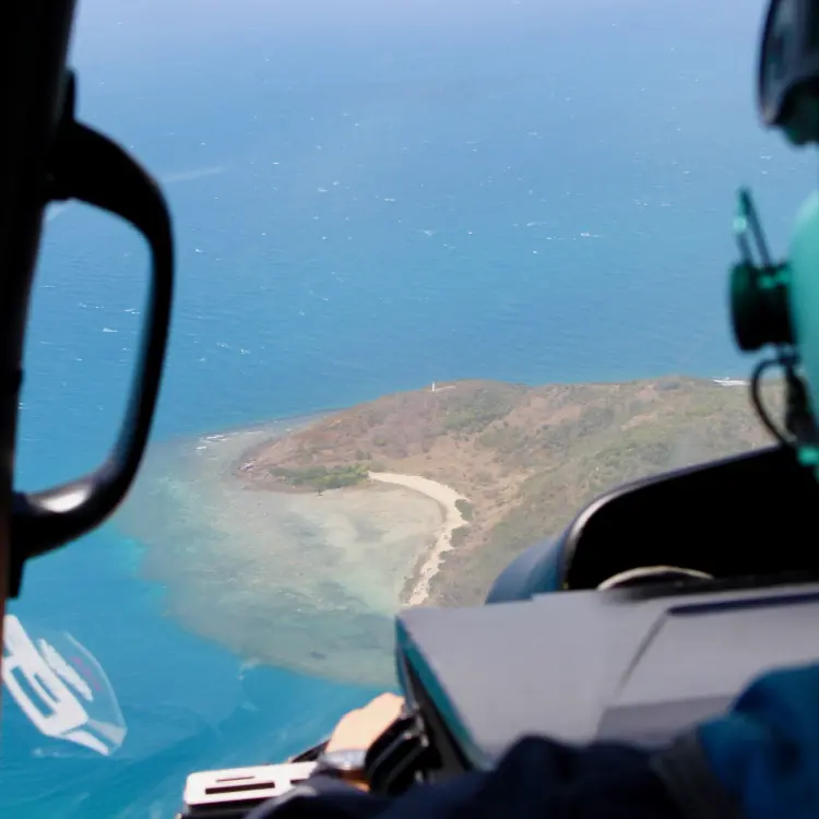 Pemandangan udara pulau pesisir kecil di Australia yang dilihat dari dalam kokpit helikopter